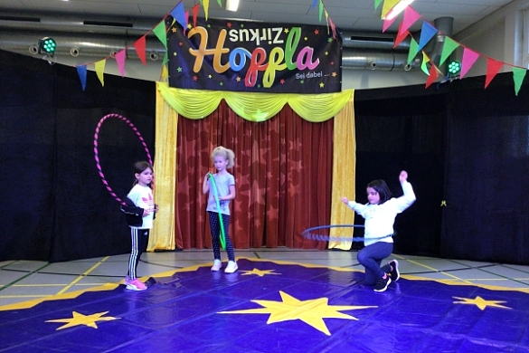 Bild von Kindern mit Hula-Hoop-Reifen in der Manege