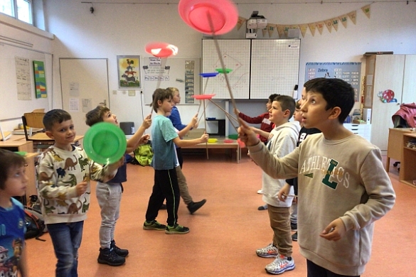 Bild von Kindern, die Teller auf einem Stab drehen