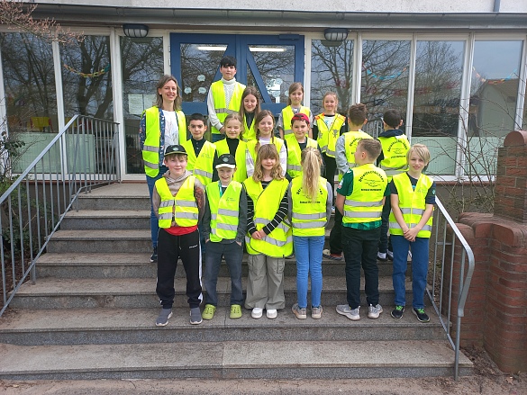 Eine Gruppe von Kinder mit gelben Westen mit einer Lehrerin