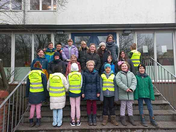 Eine Gruppe von Kinder mit gelben Westen mit einer Lehrerin
